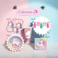 A set of unicorn-themed party supplies arranged on a pastel pink and blue background, including a hanging unicorn cutout garland, a tassel banner, a cup, a round plate, and a napkin, with a sign reading 'Unicorns' above.