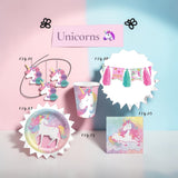 A set of unicorn-themed party supplies arranged on a pastel pink and blue background, including a hanging unicorn cutout garland, a tassel banner, a cup, a round plate, and a napkin, with a sign reading 'Unicorns' above.