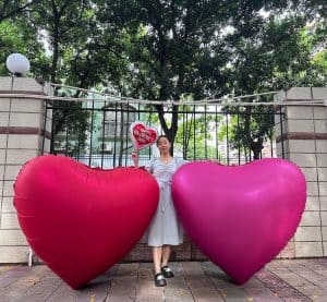 Large pink and purple heart-shaped foil balloons for celebration.