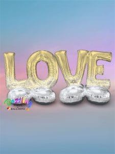 Gold foil balloons spelling LOVE with silver balloons underneath.