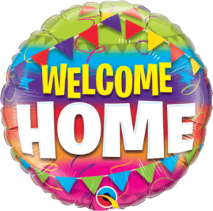 Colorful welcome home foil balloon with banners and confetti for celebrations.
