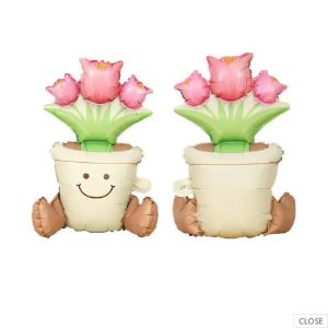Pink tulip foil balloon in a pot with smiling face and green leaves.